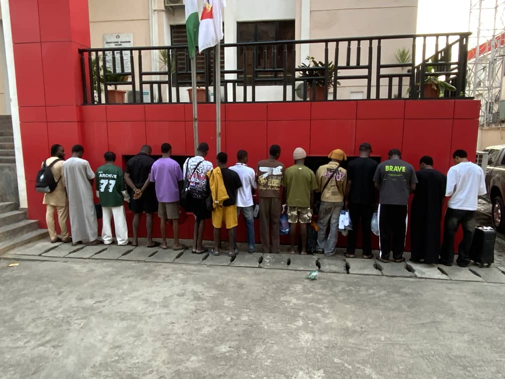 the arrested fraudsters standing in a line